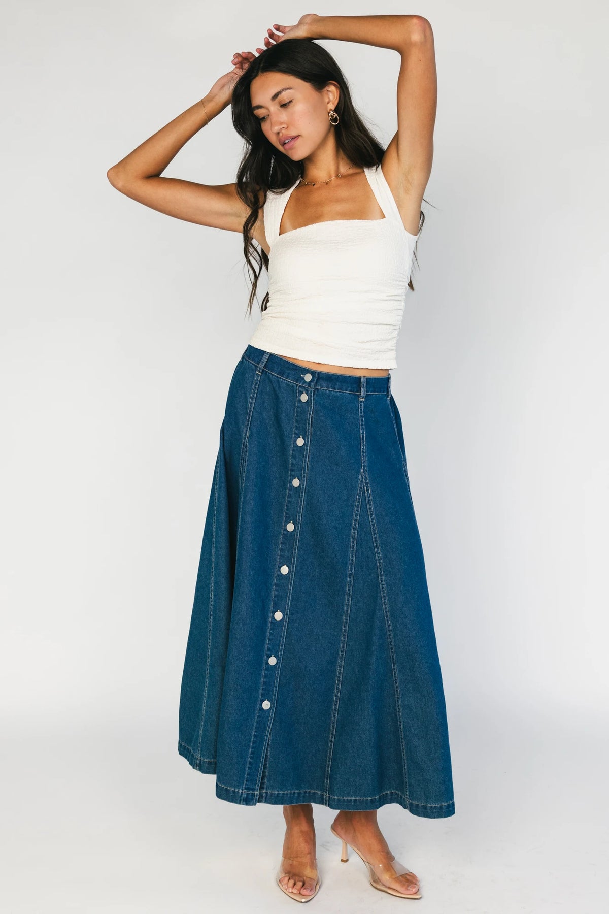 Model wearing the Cece Button-Down Denim Skirt in a dark wash featuring a button-front placket, elastic back waist, and a classic knee-length silhouette.