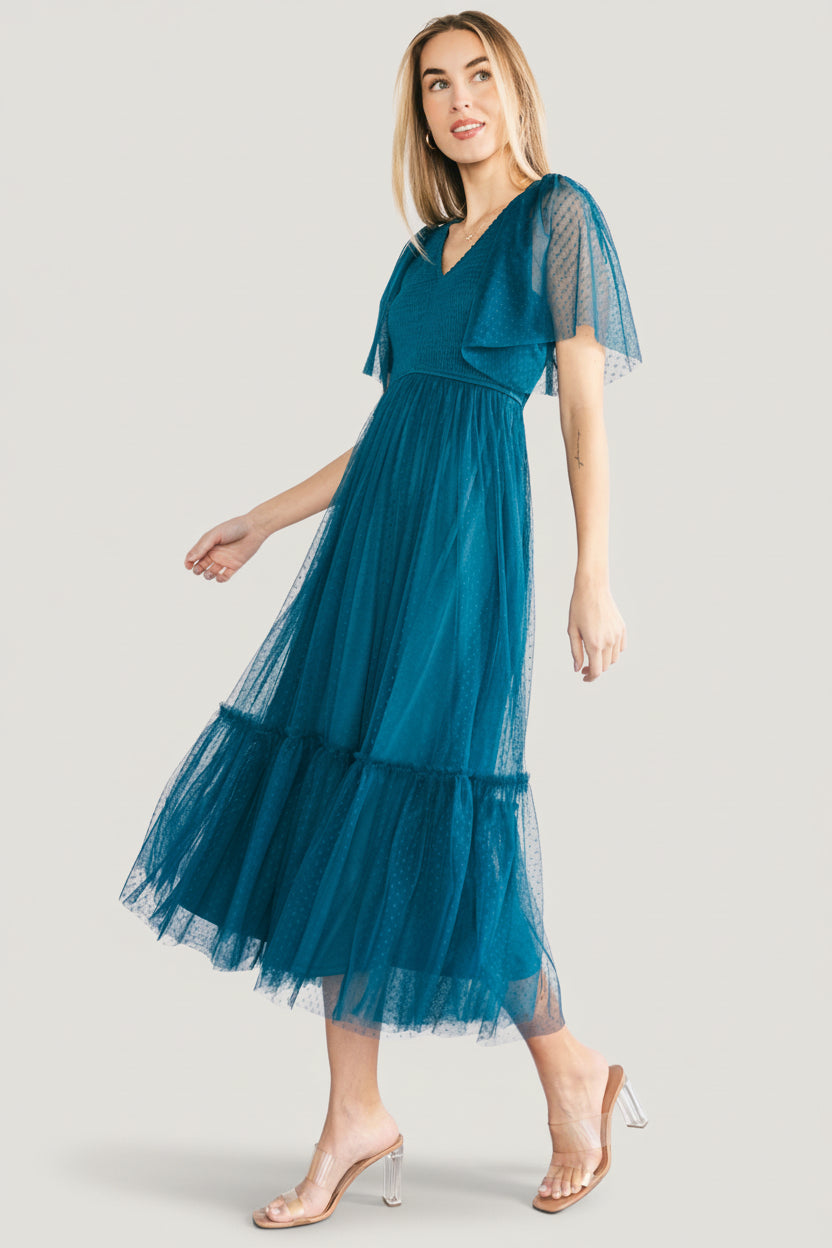 Detail image of dress fabric and texture showing the dotted tulle surface, layered lining, and close stitchwork near the sleeve and waist.