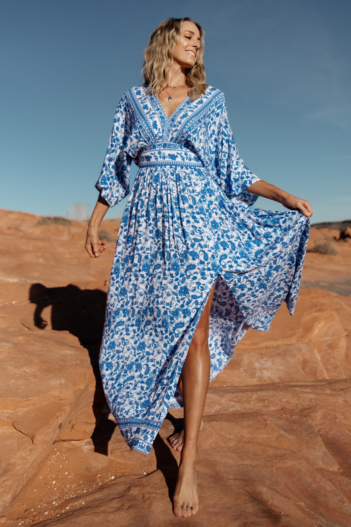 Studio flat lay of blue and white Watson kimono maxi dress showing overall print, silhouette and left leg slit.