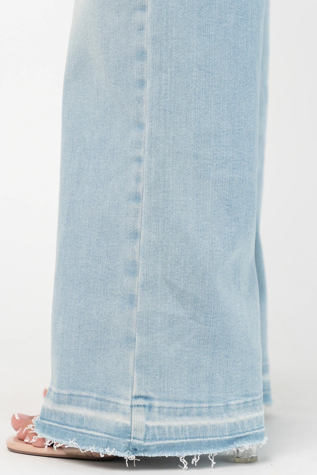 Bria High Rise Wide Leg Jeans in Light Wash with relaxed wide legs, front and back pockets, button closure, and raw hem.