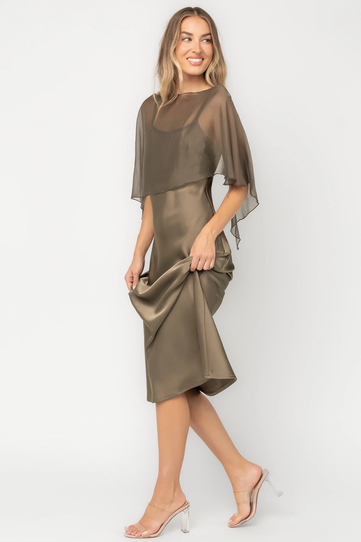 Olive satin midi dress with an attached sheer chiffon cape overlay, round neckline, hidden side zipper, and elegant slip silhouette.