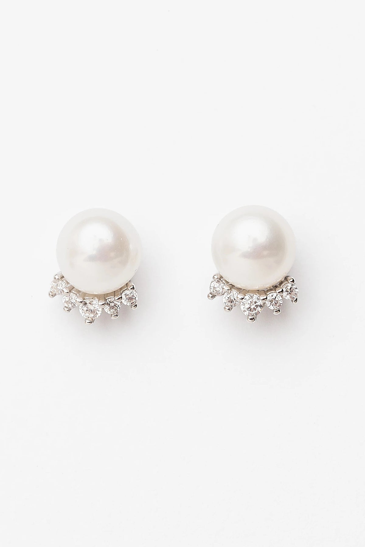 Livvy Pearl Stud Earrings with glossy pearl centers, polished sterling silver settings, and classic post backs.