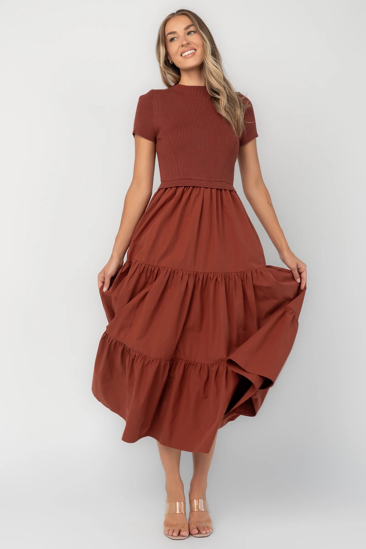 Midi dress with a ribbed knit bodice, round neckline, short sleeves, elastic waist, tiered woven skirt, and side pockets.