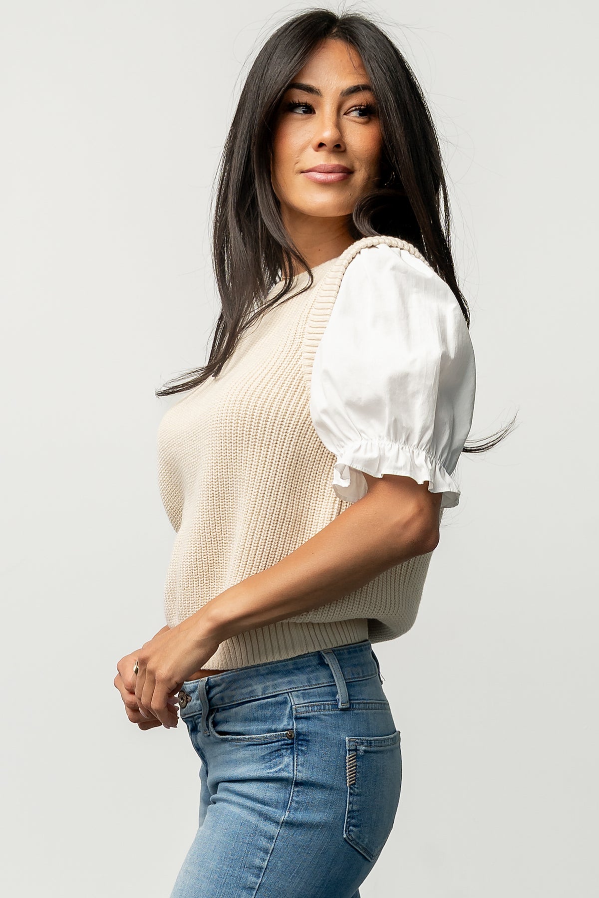 Studio detail image of the Taylor Puff Sleeve Top showing knit texture, contrast sleeve fabric and round neckline at close range.