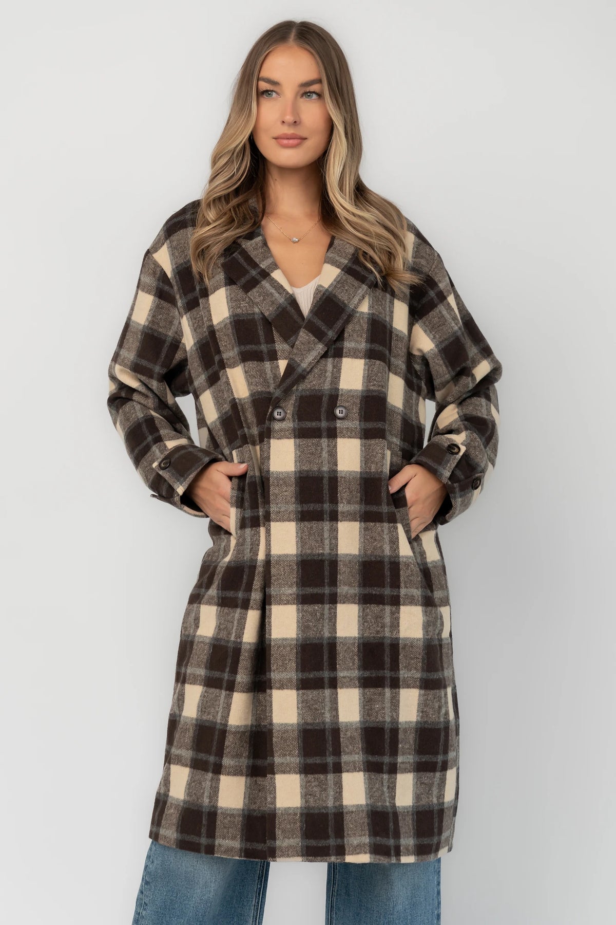 Brown plaid double-breasted longline coat with a collared lapel neckline, side pockets, back slit, and relaxed tailored fit.
