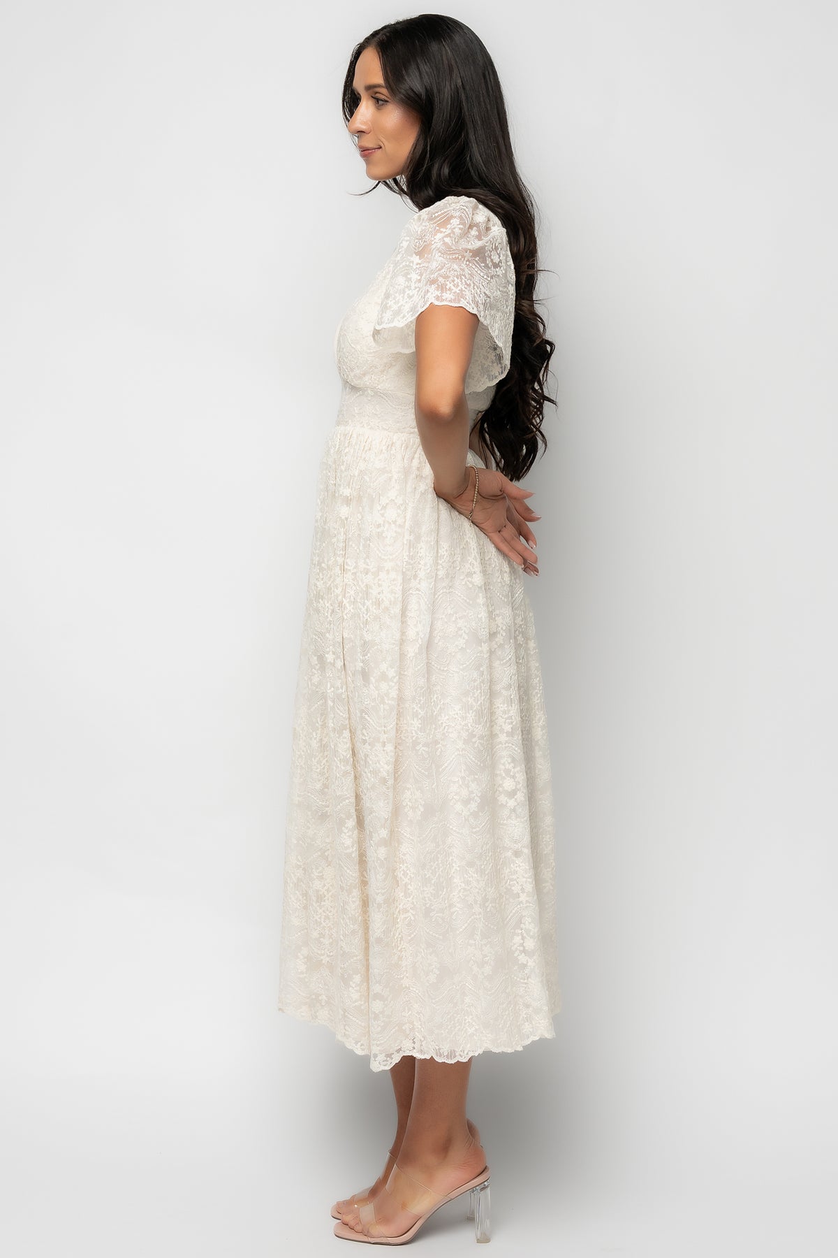 Styled flat-lay of the Aphrodite Lace Midi Dress in vintage cream showcasing lace detail, lining, and gathered waist construction.