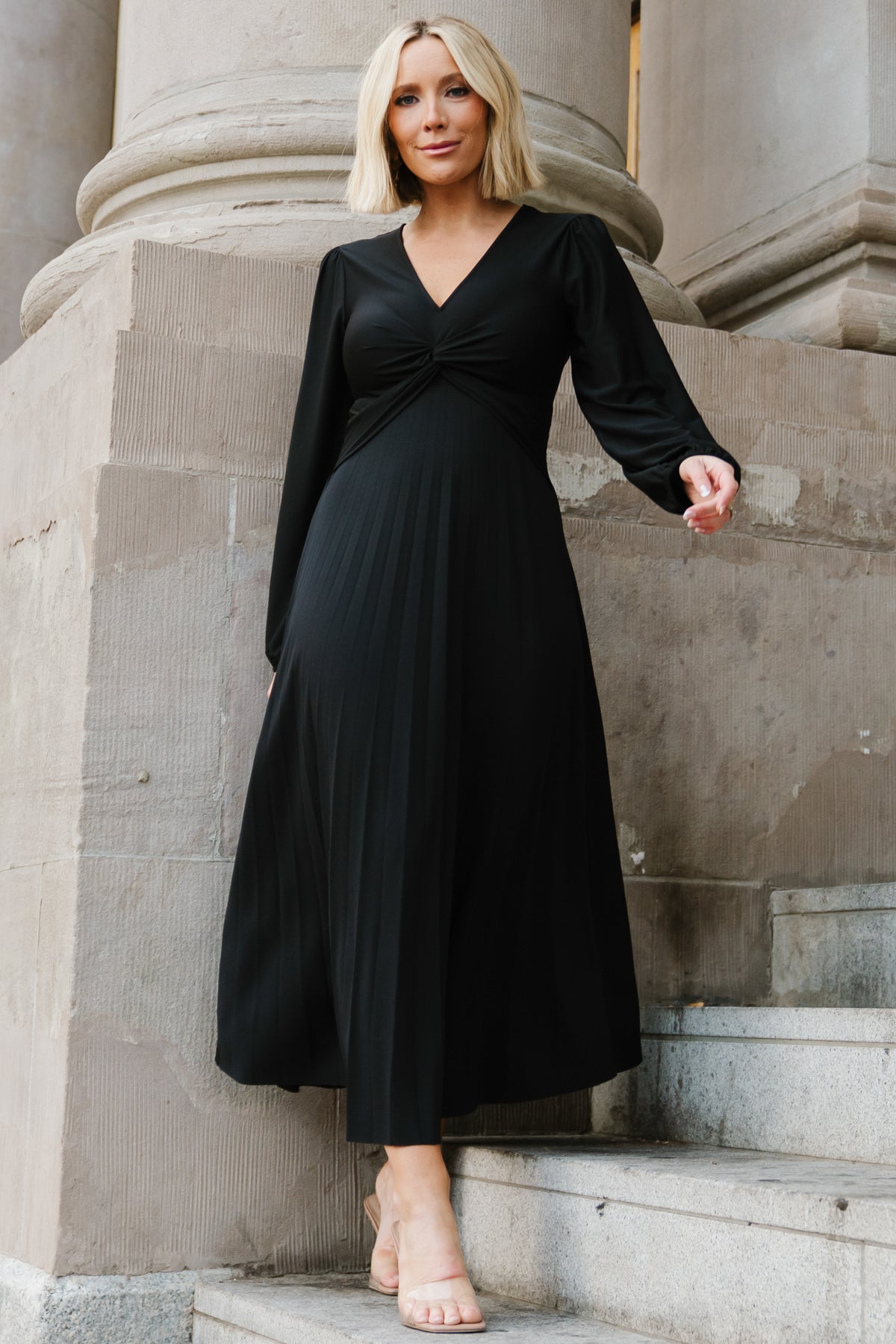 Detail shot of the luxe knit fabric texture and elastic sleeve cuff on the Lynda pleated midi dress in solid black.