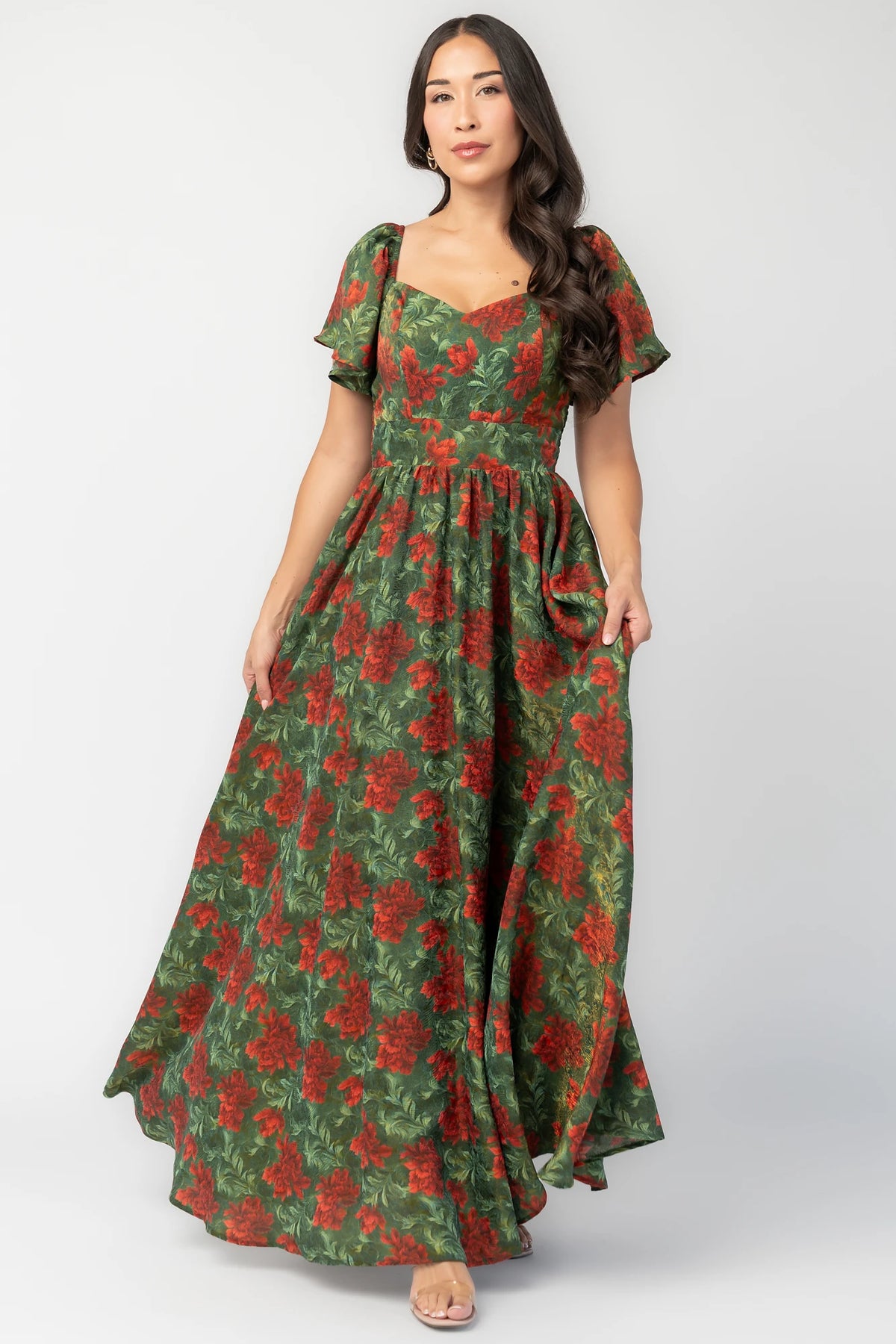 Astor Maxi Dress in Green + Red with floral print, sweetheart neckline, flutter sleeves, smocked back, and flowing skirt.