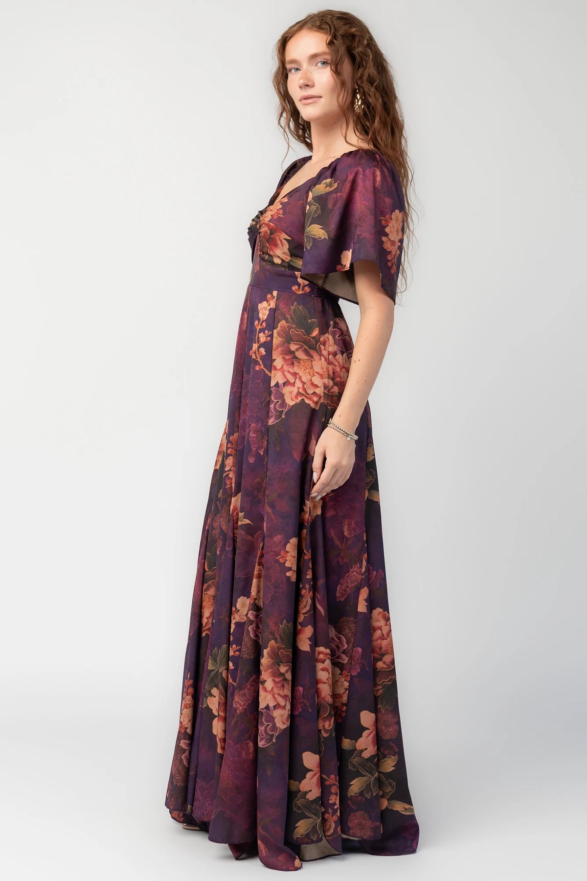 Caterina Maxi Dress in Purple Floral with knotted sweetheart neckline, flutter sleeves, smocked back, and godet skirt.