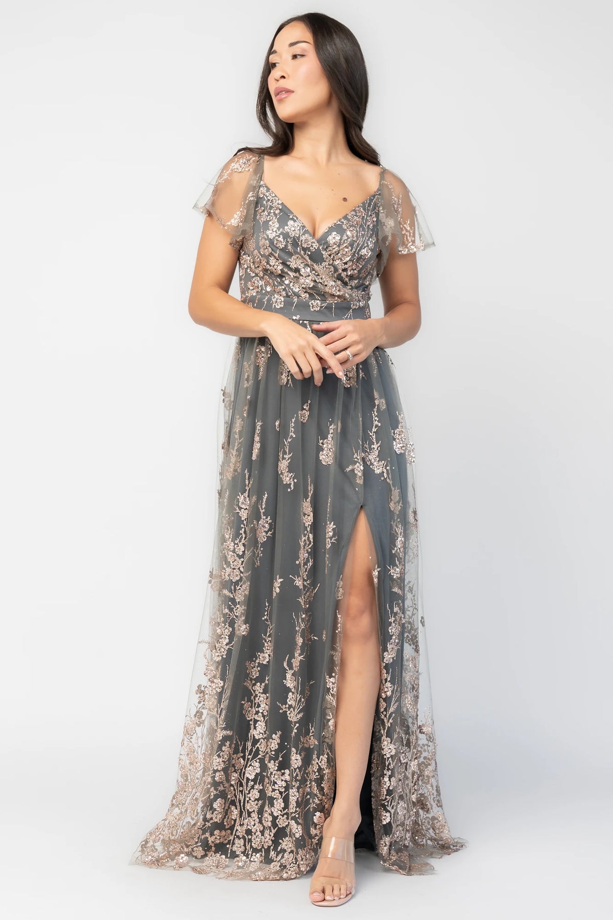 Esmerelda Shimmer Gown in Dark Sage + Rose with floral sequin embroidery, surplice V-neckline, flutter sleeves, and front slit.