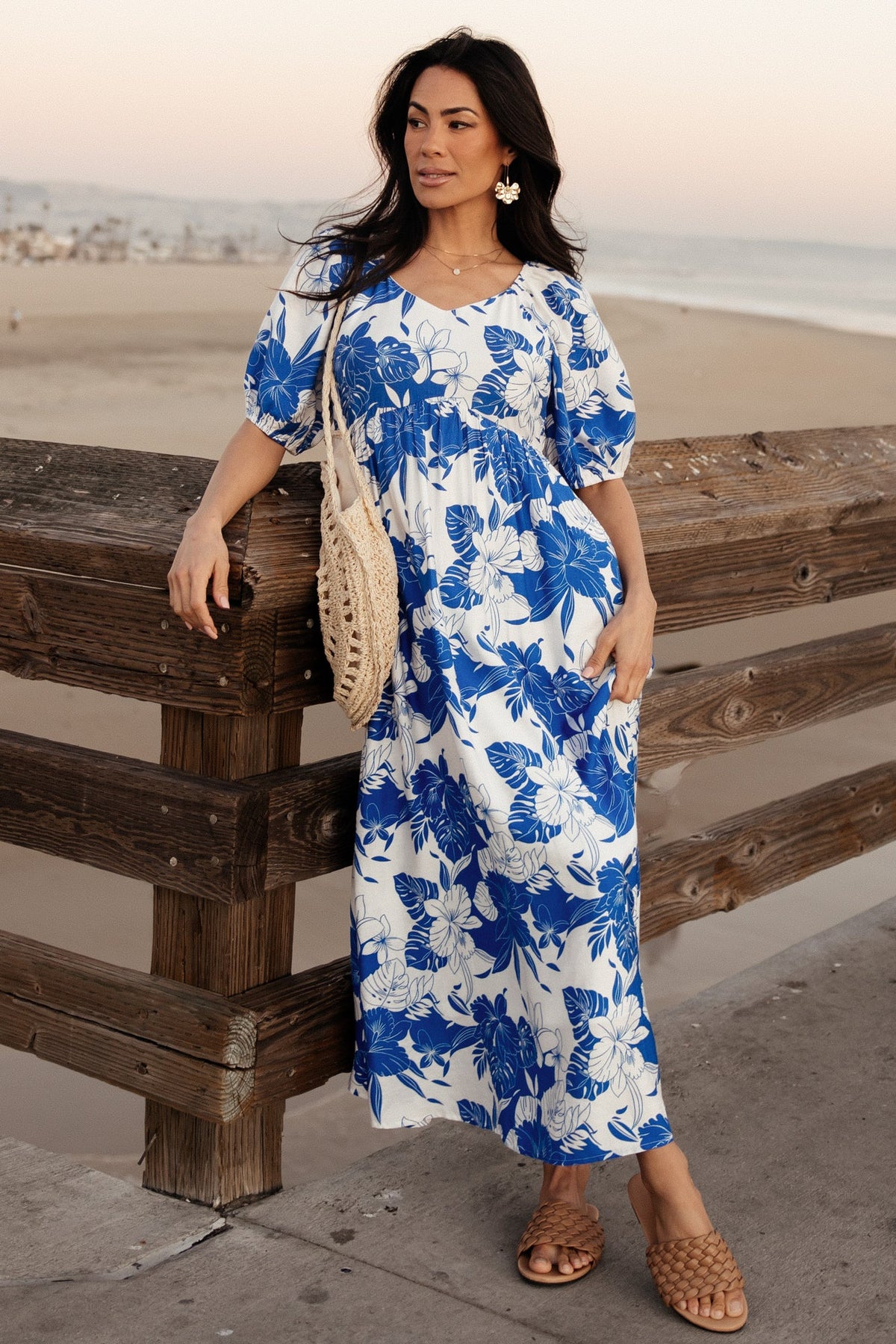 Styled detail shot of the Leela Maxi Dress fabric and sleeve cuff, showcasing the cobalt-and-off-white floral pattern and textured rayon weave.