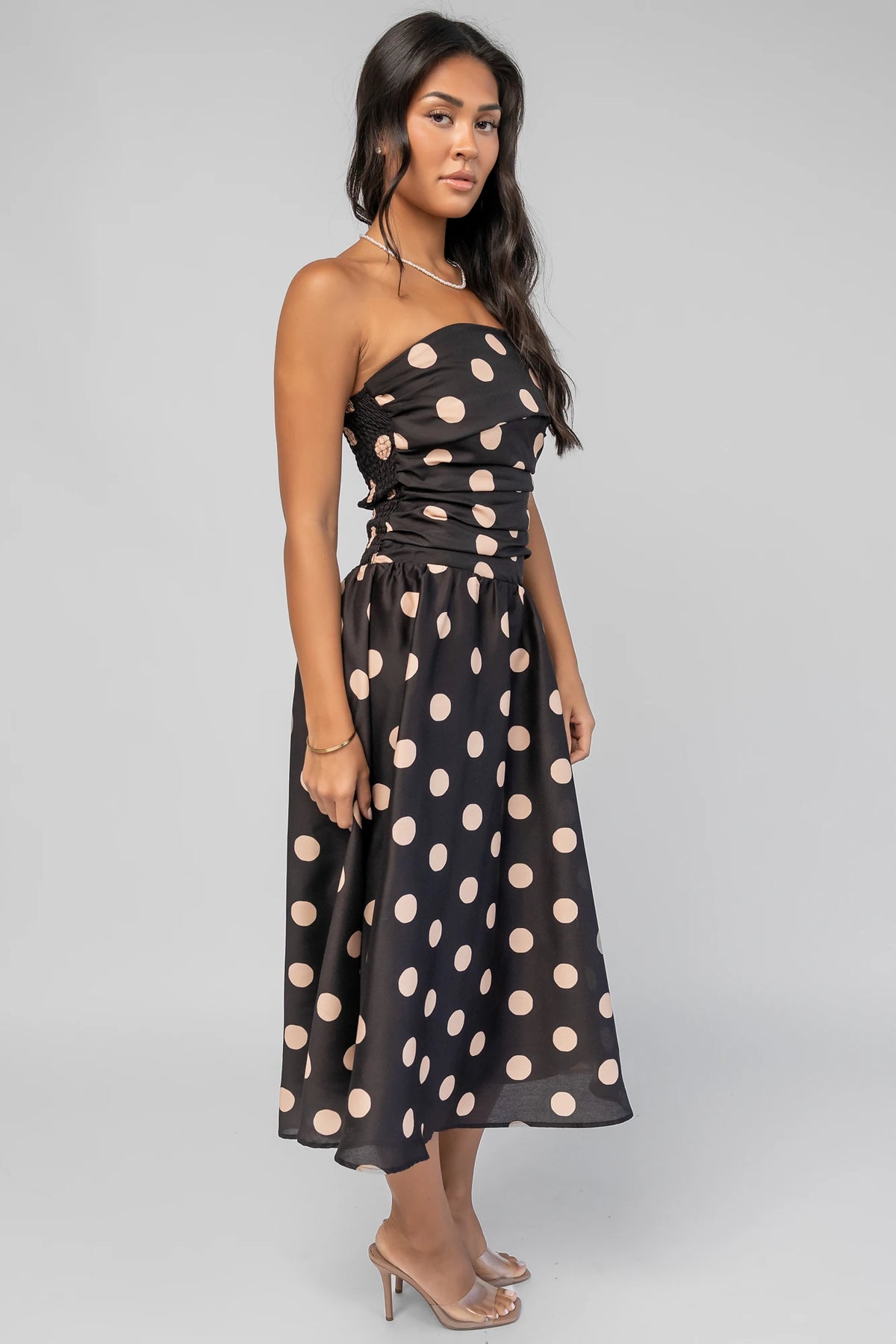 Lucienne Strapless Midi Dress in Black + Beige Dot with strapless neckline, cinched bodice, smocked back, and dropped waist.