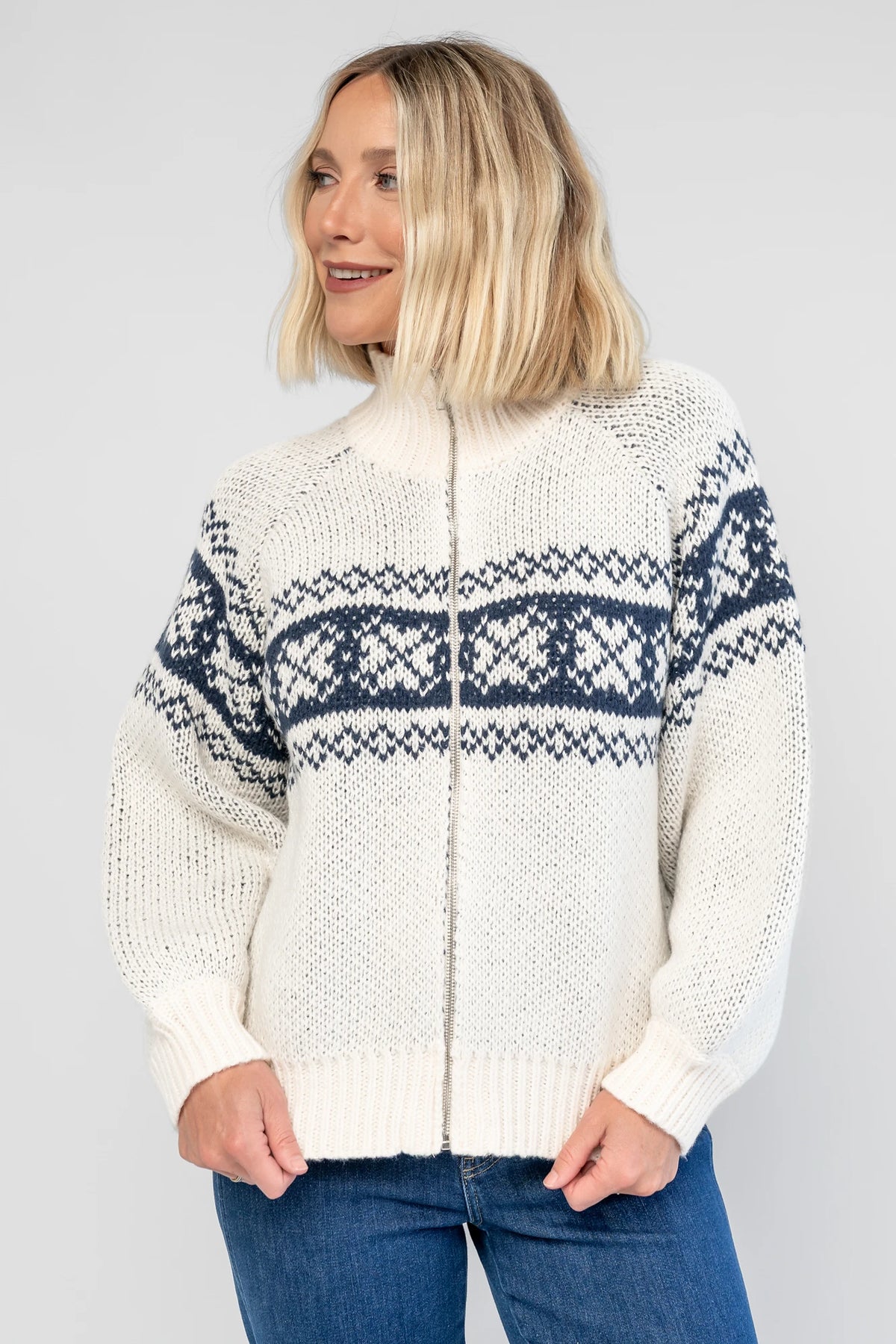 Neve Sweater Jacket in Cream + Navy with a Fair Isle knit pattern, turtleneck, silver zip-front design, and cozy thick knit.