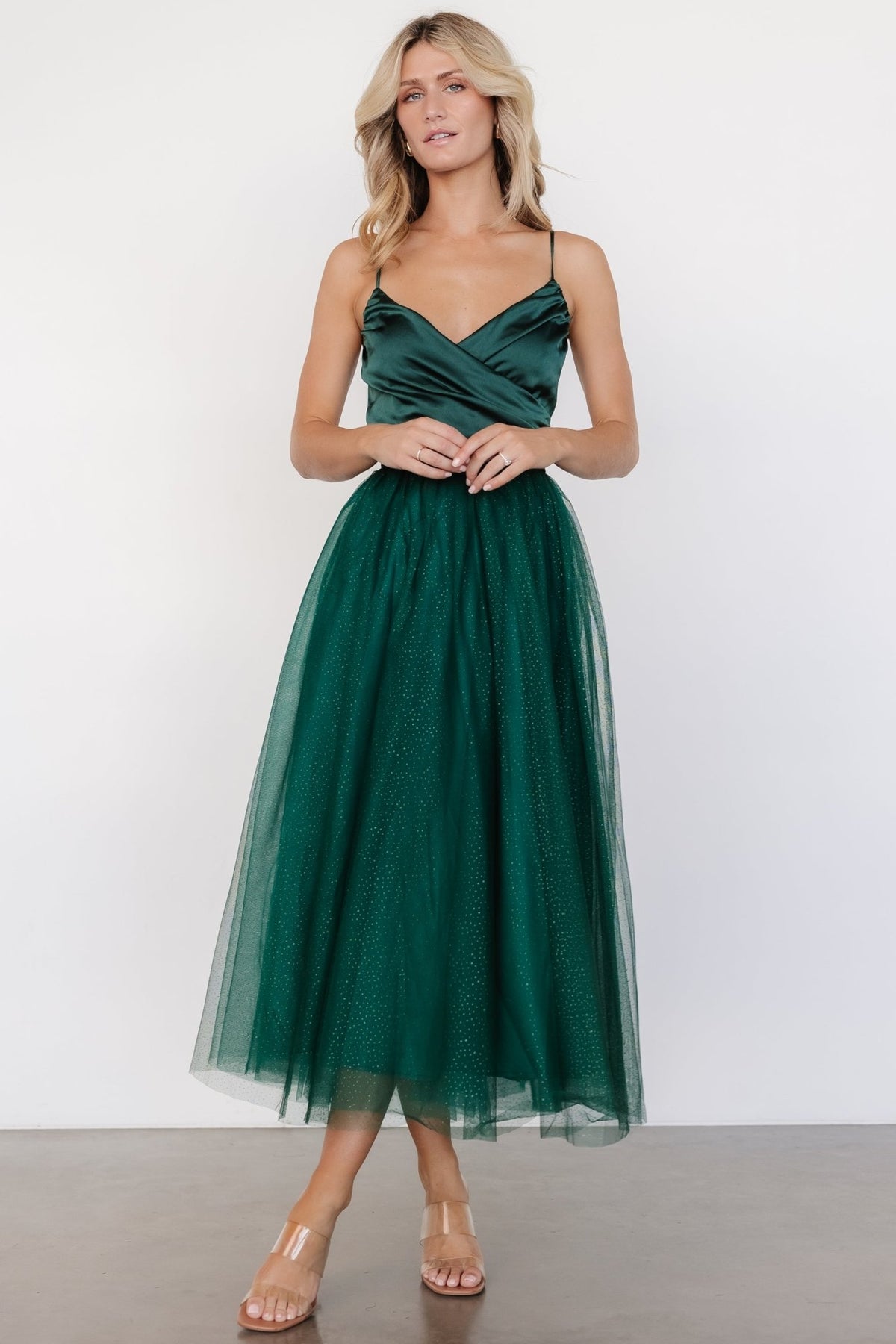 Model wearing the emerald Shonda Sparkle midi dress, showcasing flattering fit, smocked back, and delicate sparkle on the tulle layers.