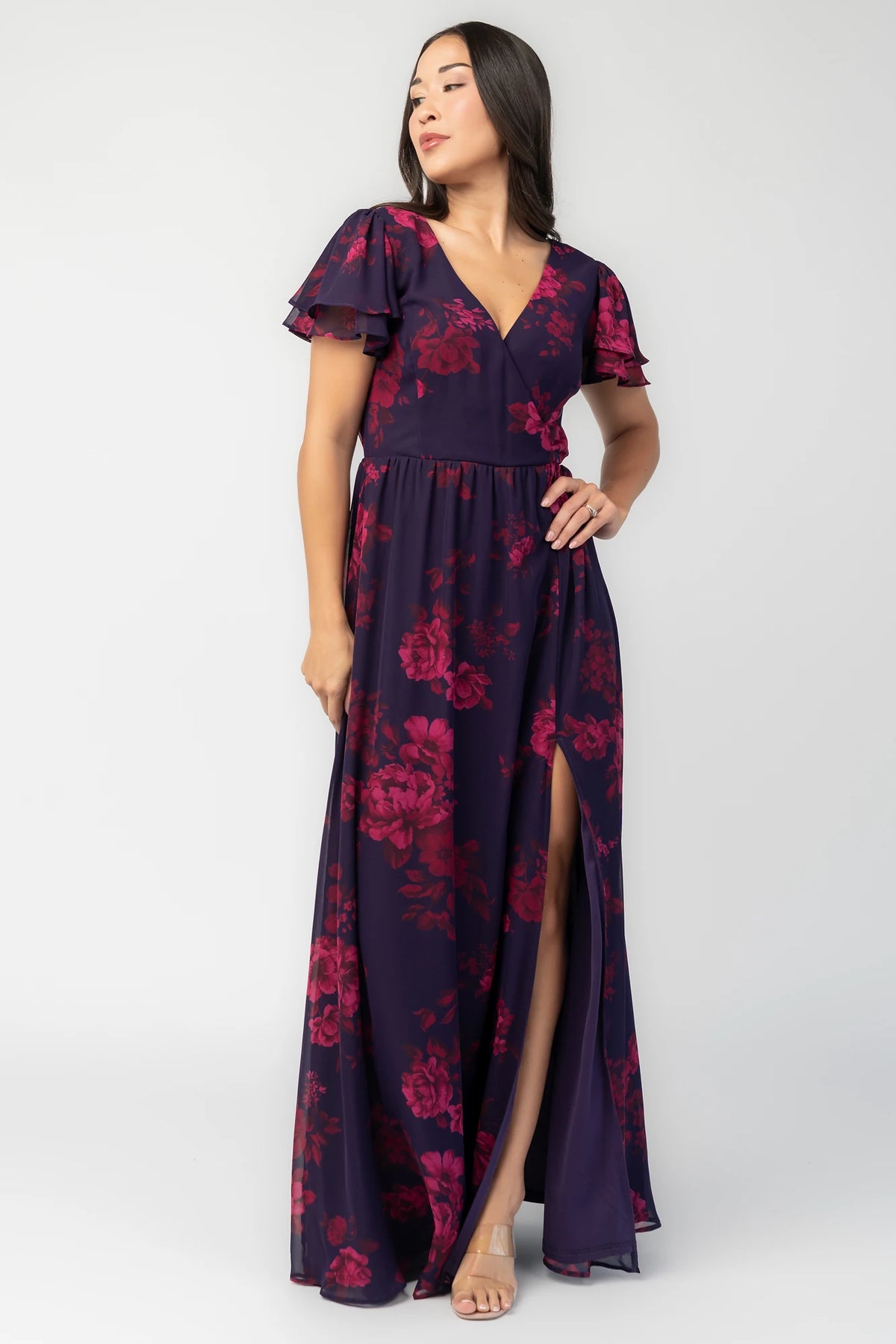 Theodora Maxi Dress in Indigo + Berry with floral print, crossover V-neck, flutter sleeves, elastic waist, and leg slit.