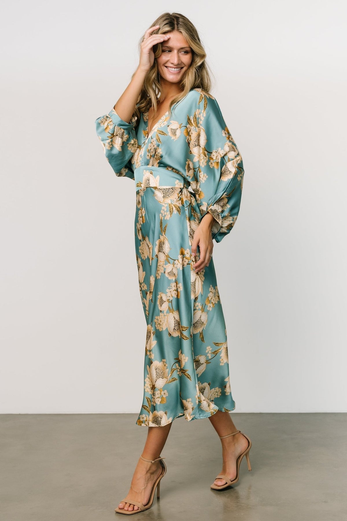 Styled look of Joni Satin Midi Dress with sash tied at waist, showcasing blue multi floral print and evening-ready finish.