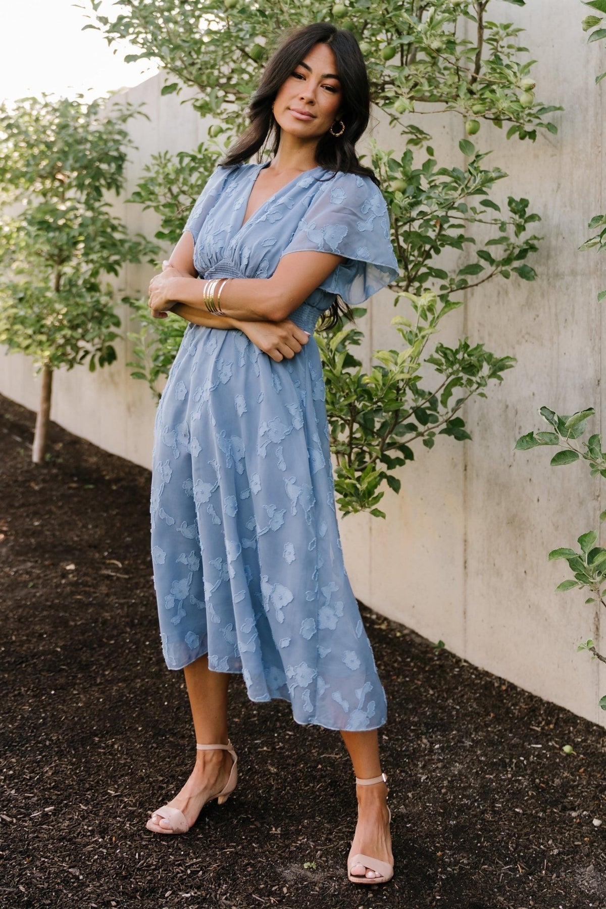 Styled outfit view of blue smocked midi dress paired with accessories, showcasing its versatility for both casual and formal occasions.
