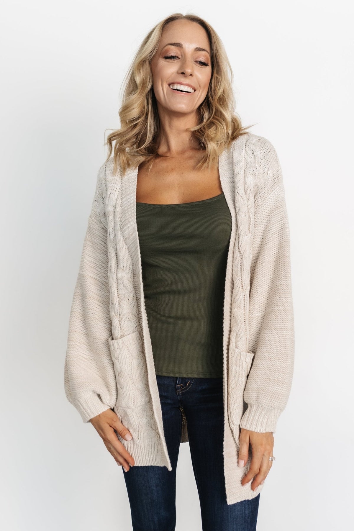 Model styling the oatmeal Spencer cardigan with jeans and boots, highlighting versatile transitional-season wearability.