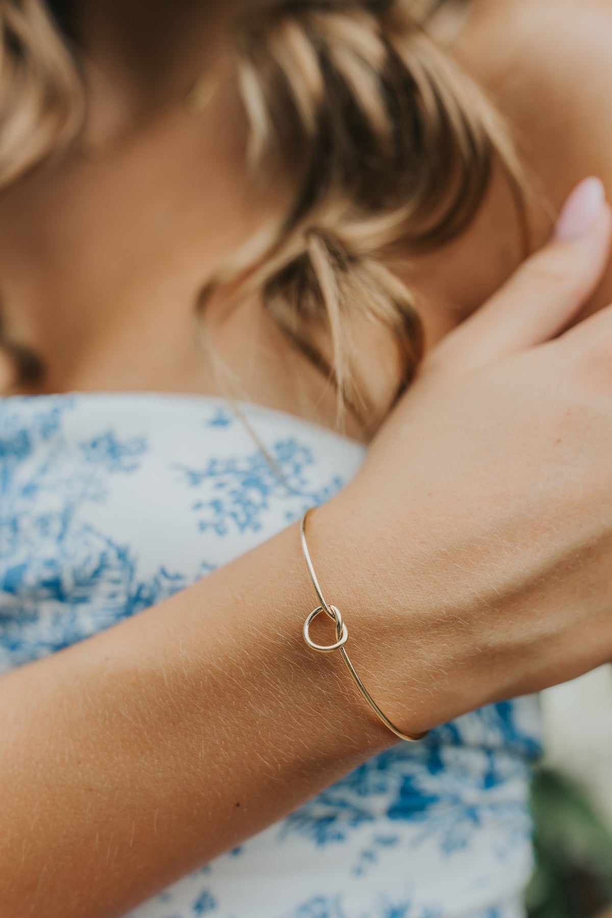 Side angle of The Kate Bangle showing the open cuff gap and smooth rounded finish of the 18K gold plating over surgical-grade titanium.