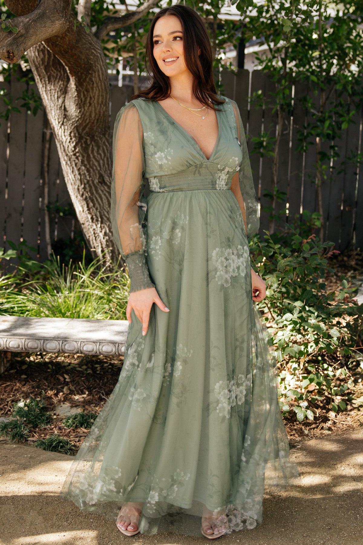 Front view of dusty green floral Layla tulle maxi dress on model, deep V-neck, long sheer sleeves, smocked waist and flowing skirt, studio lighting