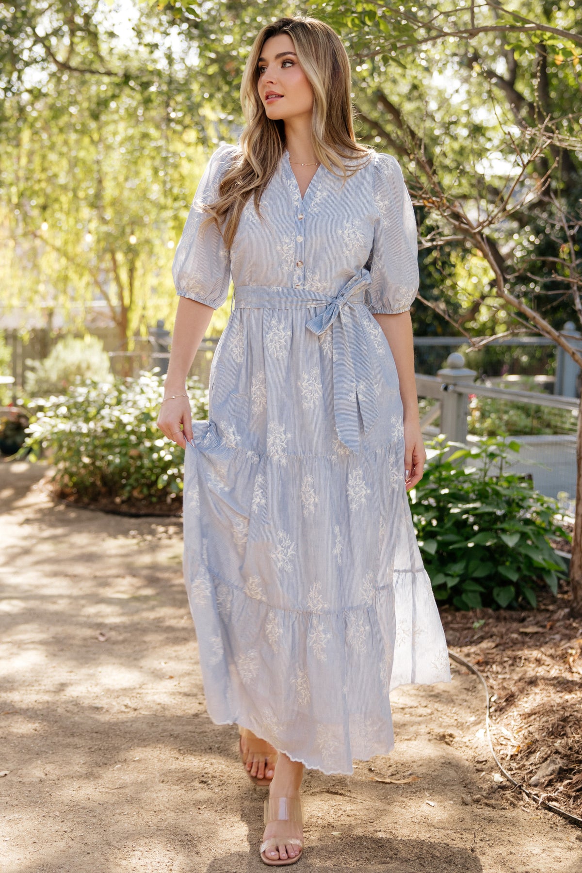 Detail of V-neck bodice with functional buttons and delicate embroidery, showing lining and button placement on the dress.