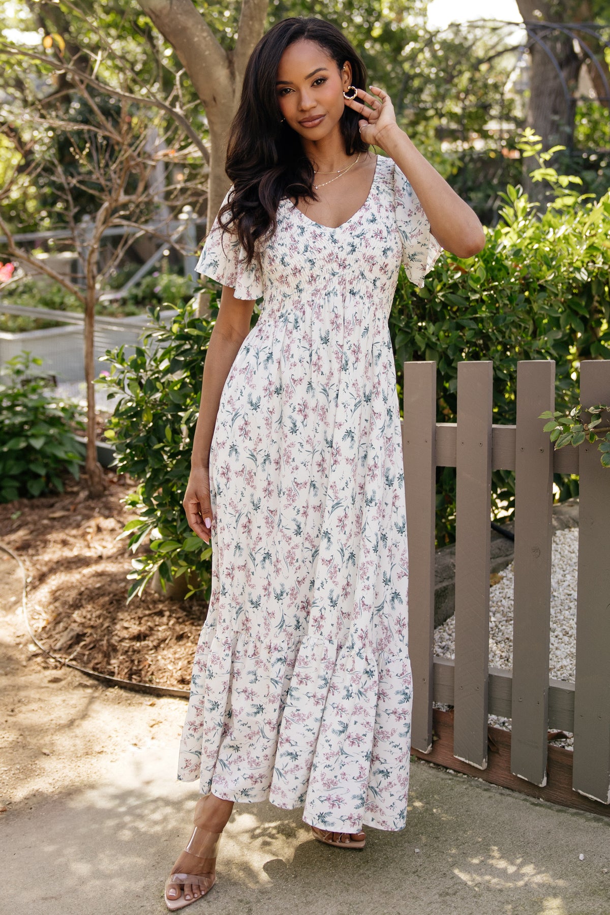 Front full-length view of Joanie smocked midi dress in cream multi floral showing smocked bust, wide V-neckline, flutter sleeves, and flowy skirt.