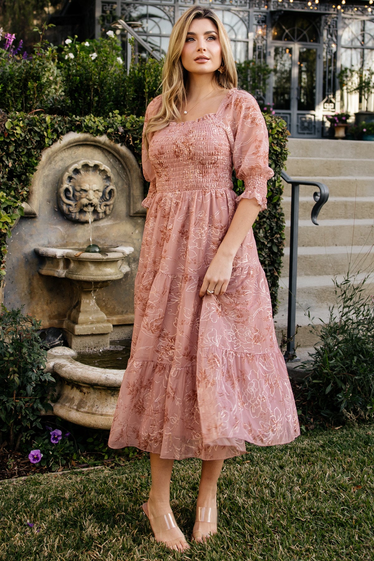 Front view of a model wearing the Fabian Jacquard Midi Dress in Mauve + Gold, showing square neckline, smocked bodice, and tiered midi skirt movement.
