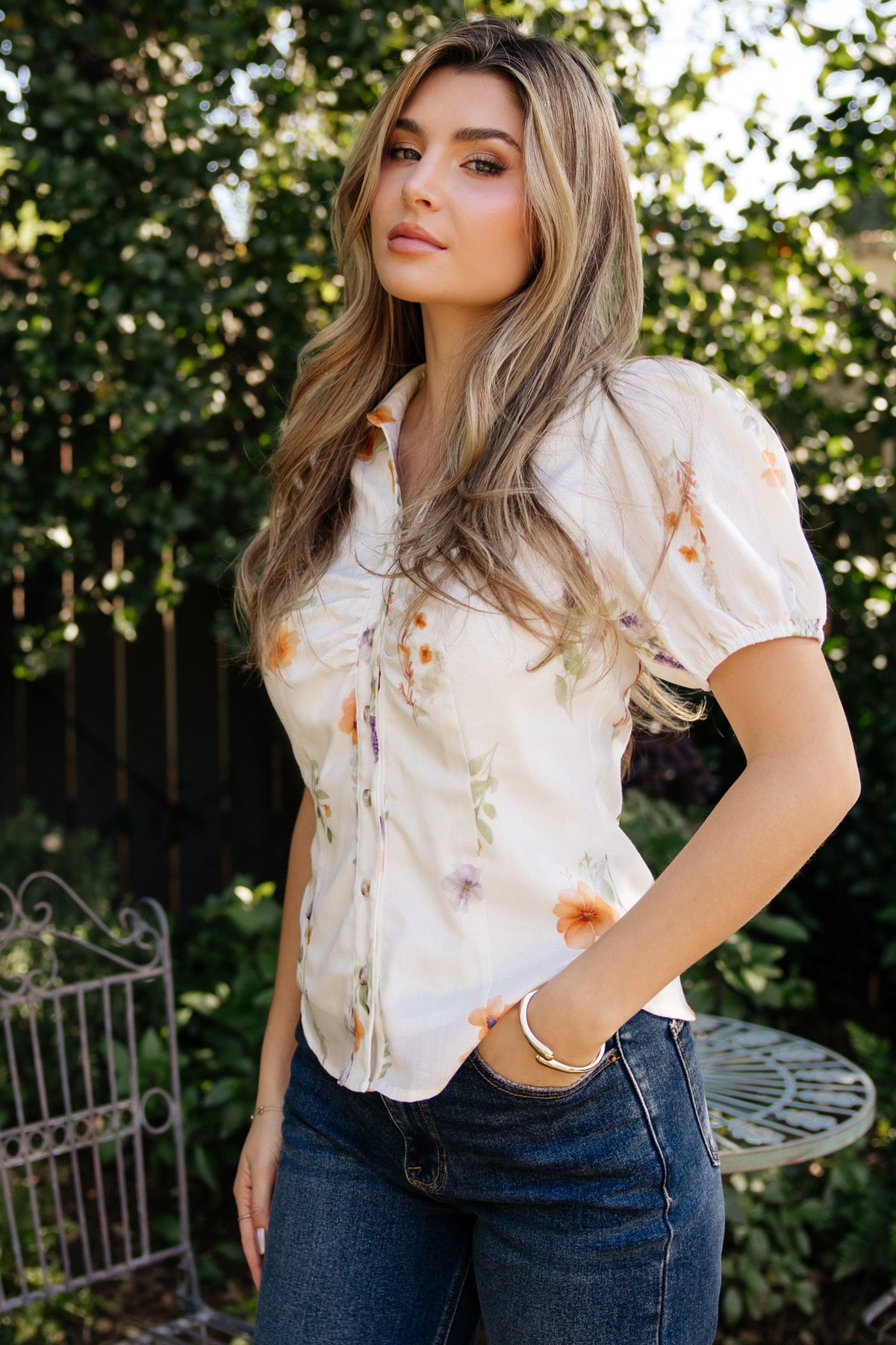 Detail shot of the Fiona blouse buttons and ruched bust: clear functional front buttons, neat stitching, and textured elastic cuff on short sleeve visible on the model.