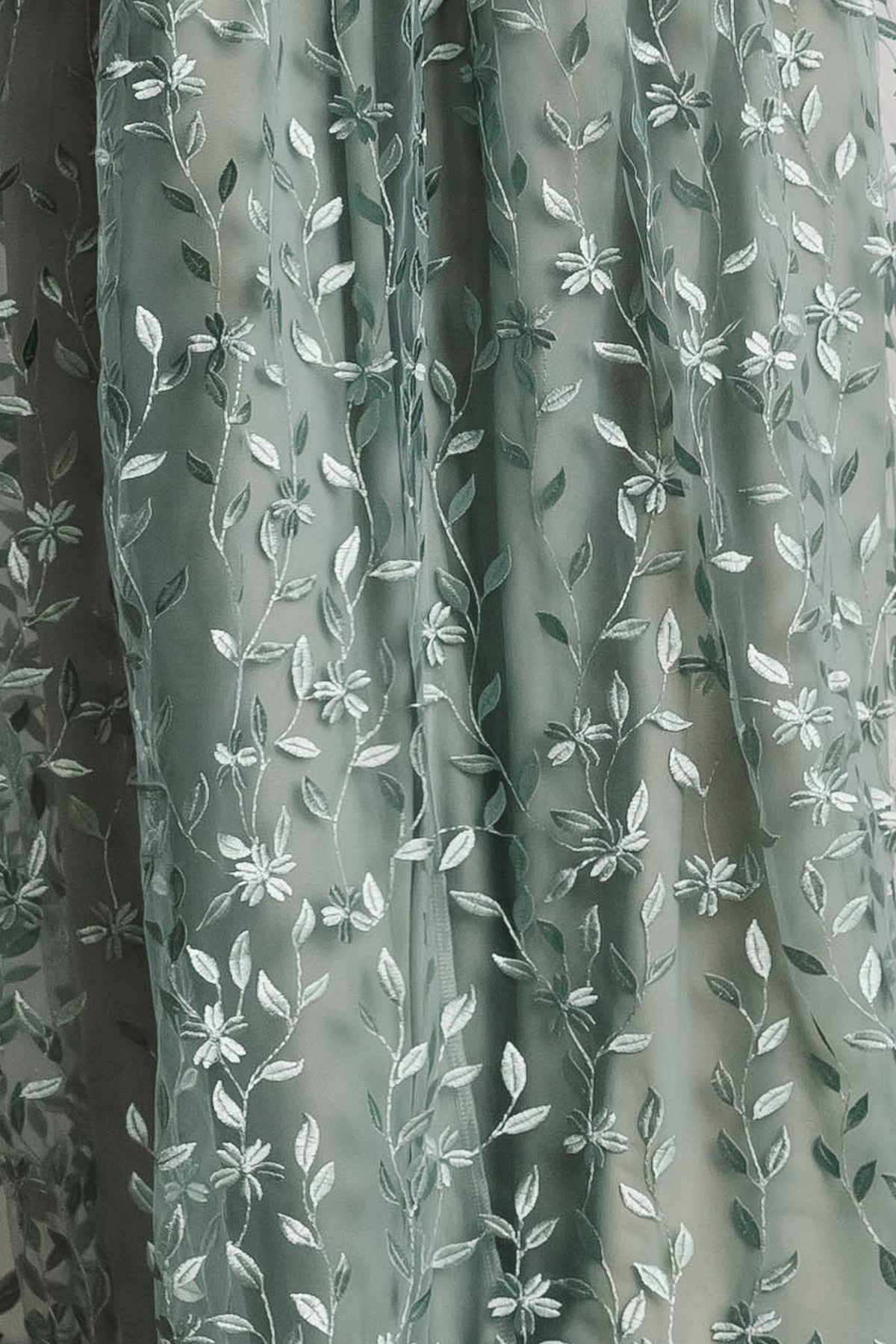 Close-up of Marseille Embossed organza fabric swatch in eucalyptus green showing vine-embossed texture and subtle sheen, 3x4 sample.
