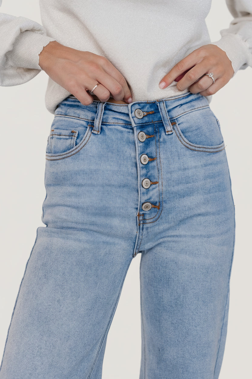 Back view of Brody jeans on model, showing back pockets, high-rise shaping, and the relaxed wide-leg silhouette in light wash denim.