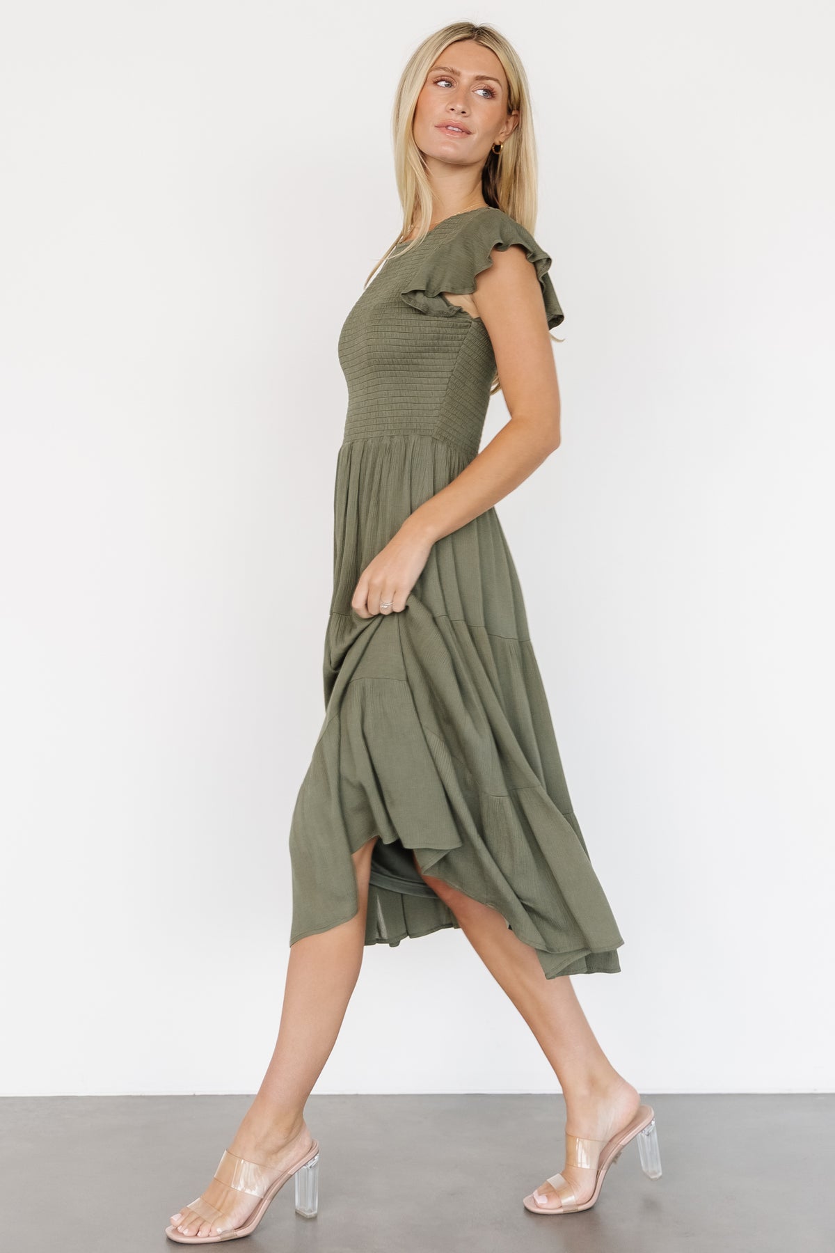 Close-up of Loretta Dress bodice in dark sage highlighting smocked texture, round neckline, and delicate fabric drape at the tiers.