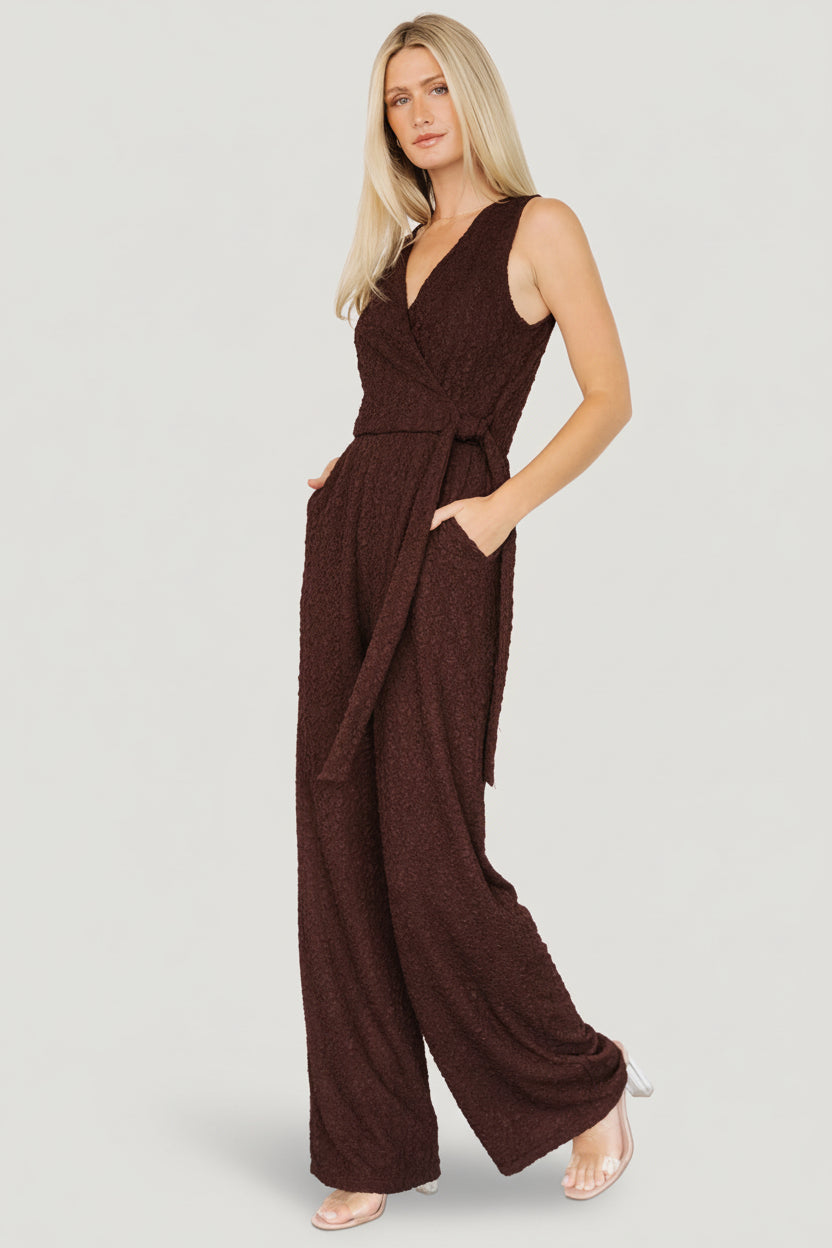 Close-up of crepe-textured fabric and surplice neckline with subtle stretch; bust area is lined for coverage while body drapes smoothly.