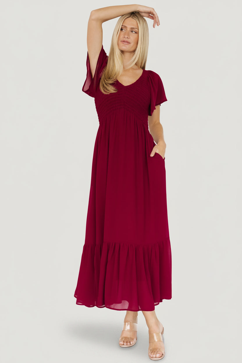 Back and movement shot of mulberry maxi dress illustrating flowing tiered skirt and flutter sleeve silhouette.