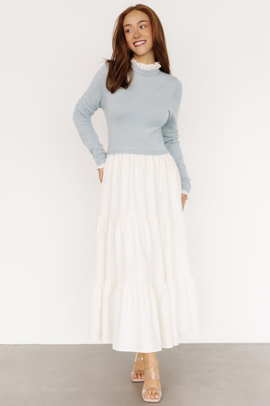 Front view of Sophie Sweater Dress in light blue and ivory showing ruffled neckline, long sleeves, and tiered maxi skirt with pockets, on model.