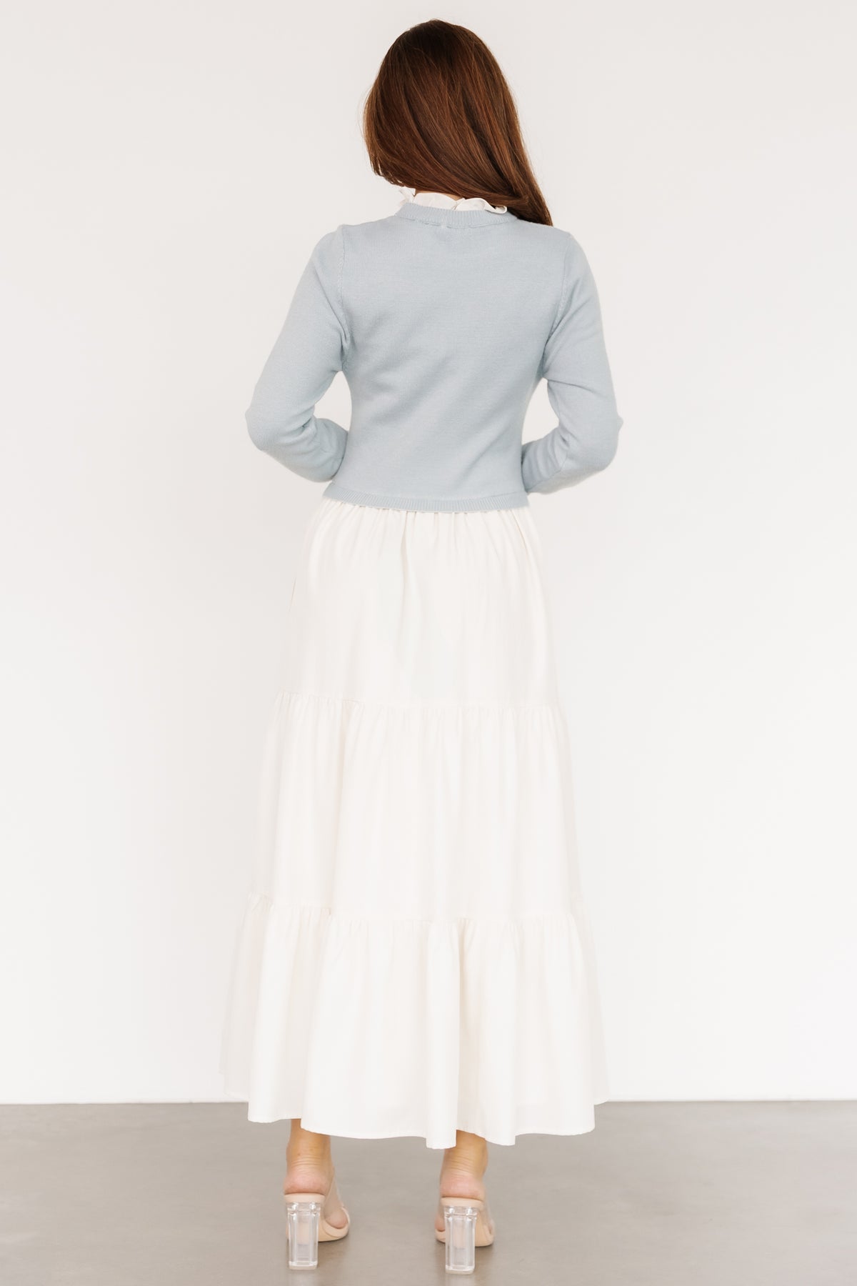Side view of Sophie Sweater Dress in light blue with hand in hidden side pocket, demonstrating practical pocket placement and skirt fullness.
