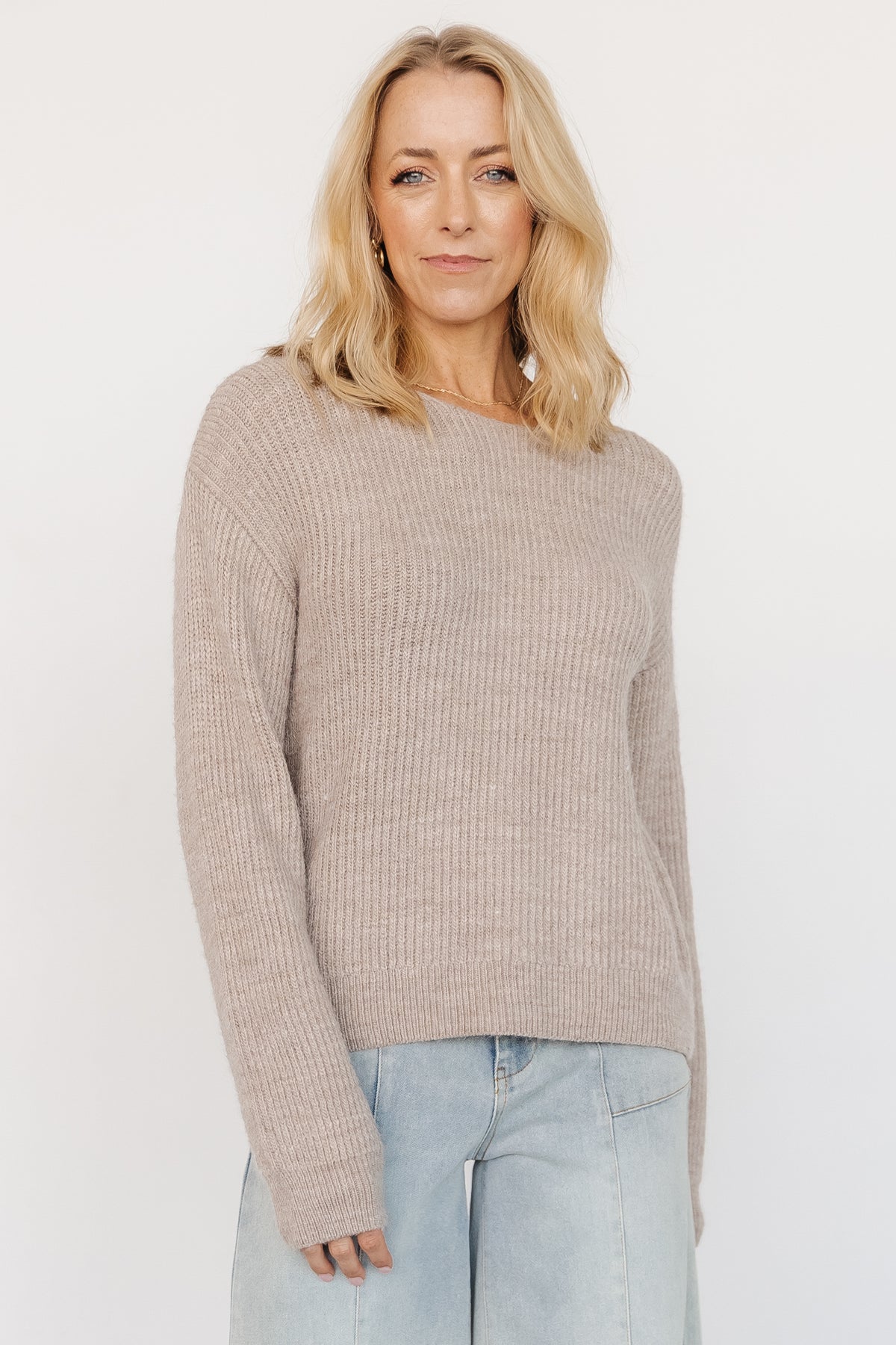 Model wearing Viola Tie Back Sweater in Natural, front view showing boat neckline, relaxed drop shoulders, and soft sweater knit texture.