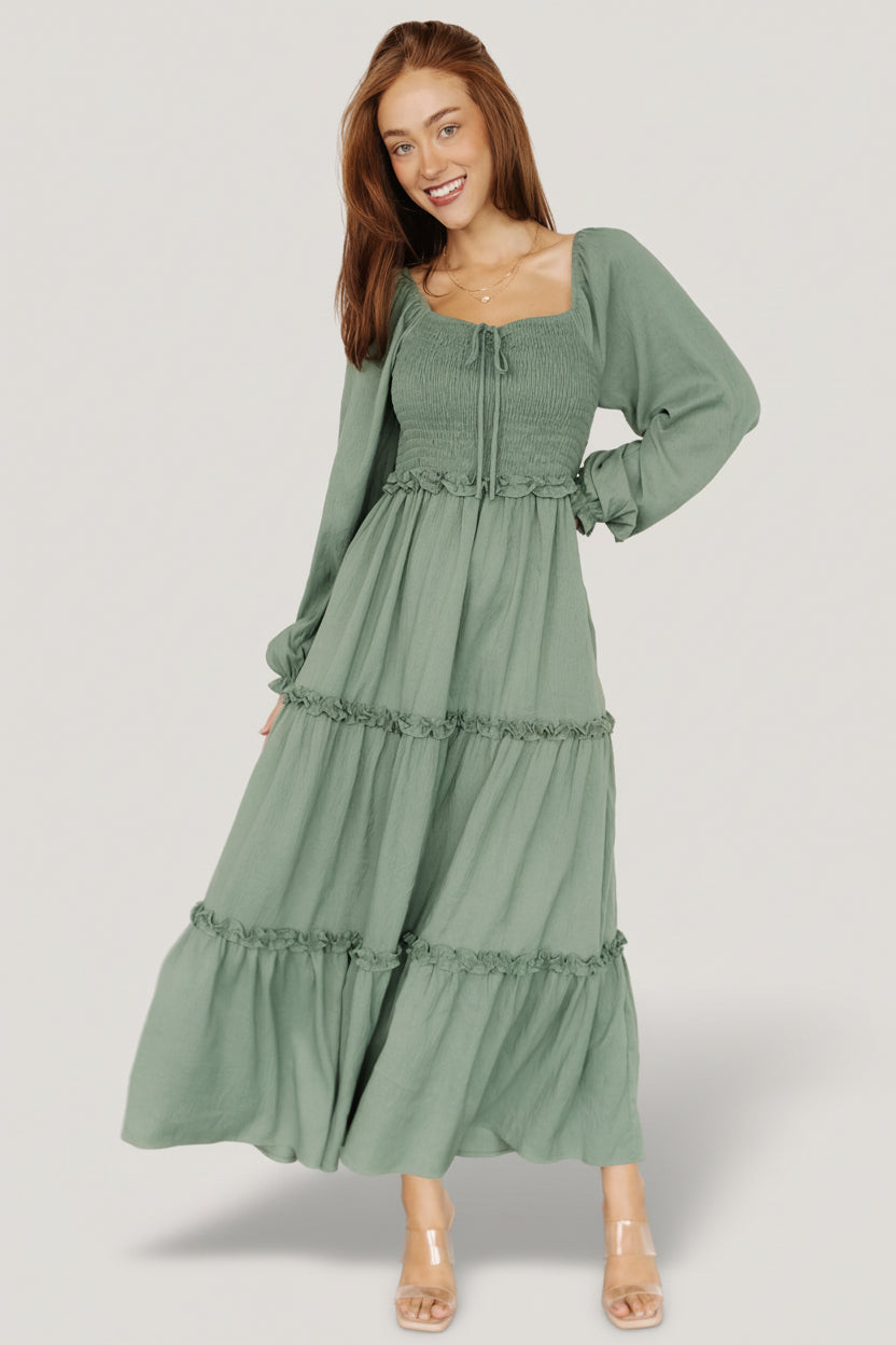 Front view of the Britta Maxi Dress in dark sage showing smocked bodice, sweetheart neckline, faux bow cinch and three-tier ruffle maxi skirt.