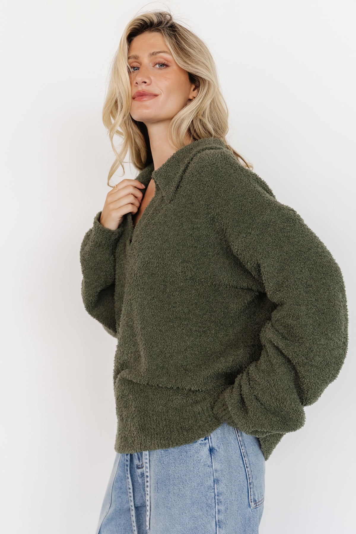 Close-up of Lockwood sweater fabric in muted green highlighting fuzzy knit pile, subtle stretch and ribbed cuff detail.