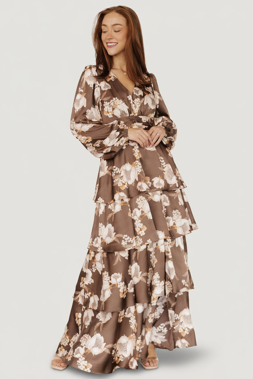 Back view displaying the smocked panel for stretch, the contoured waistline and the flowing maxi silhouette in mocha floral satin.
