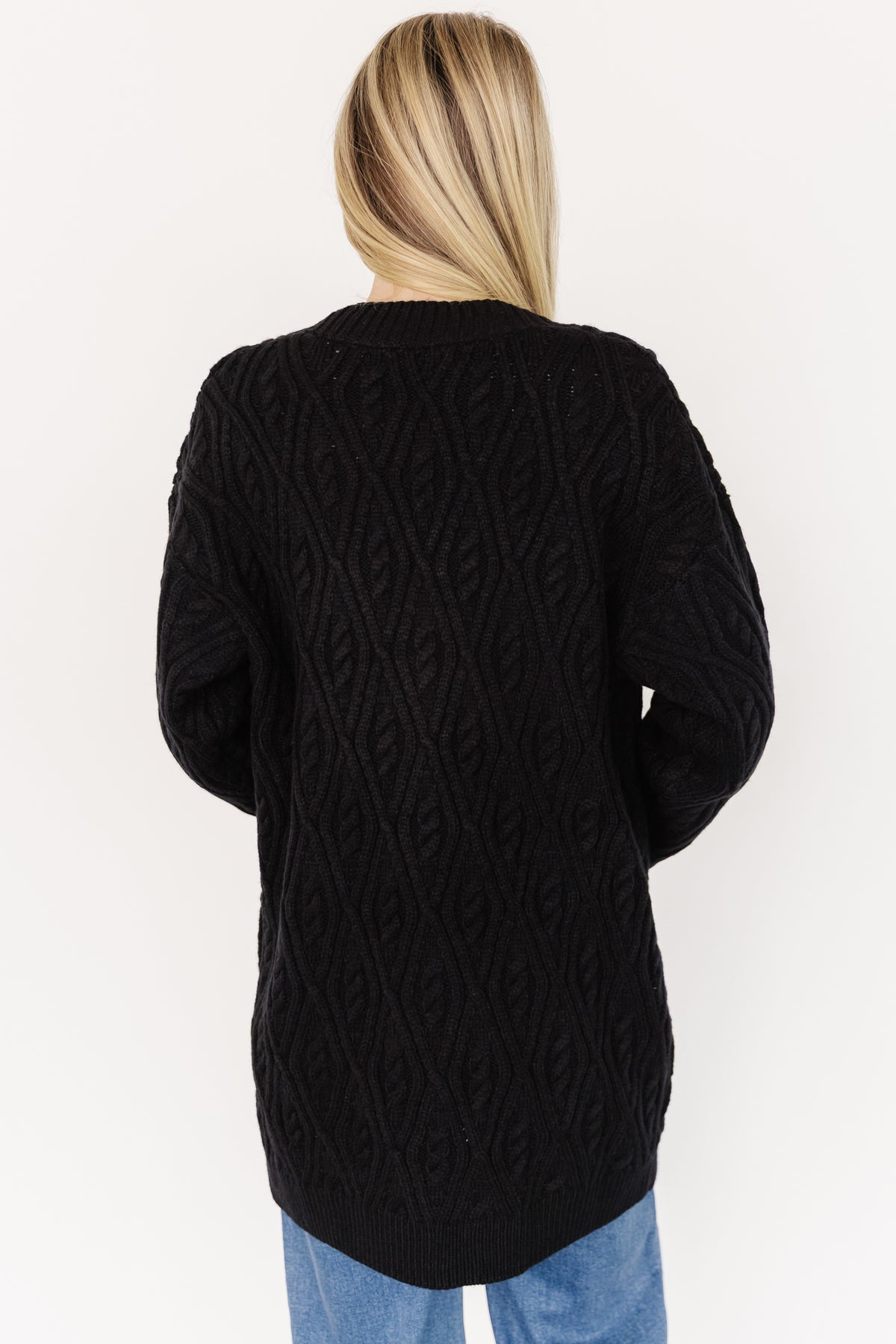 Model wearing the Alberta Cardigan in black viewed from the back, displaying dropped shoulder seam and relaxed, easy fit through the body.