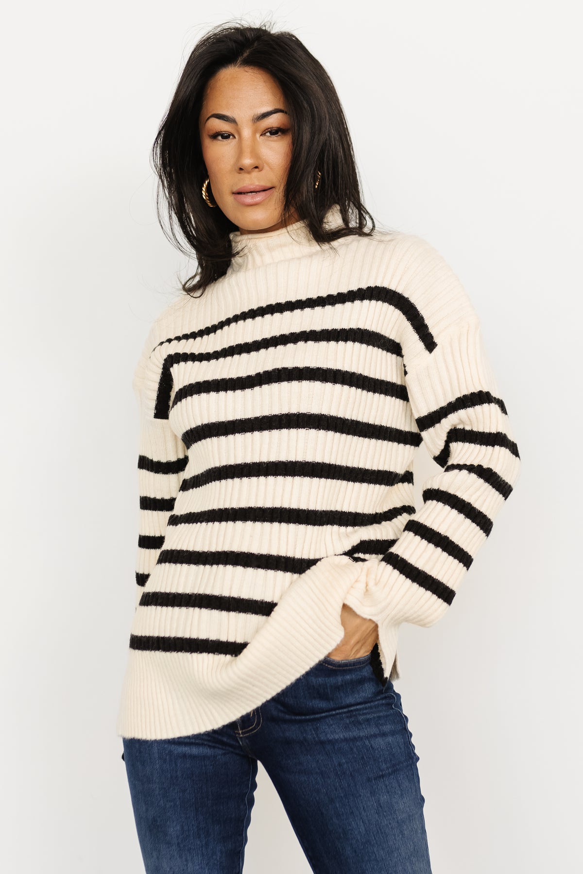Lifestyle image of Landell ivory and black striped sweater styled for casual wear, showing length and relaxed silhouette.