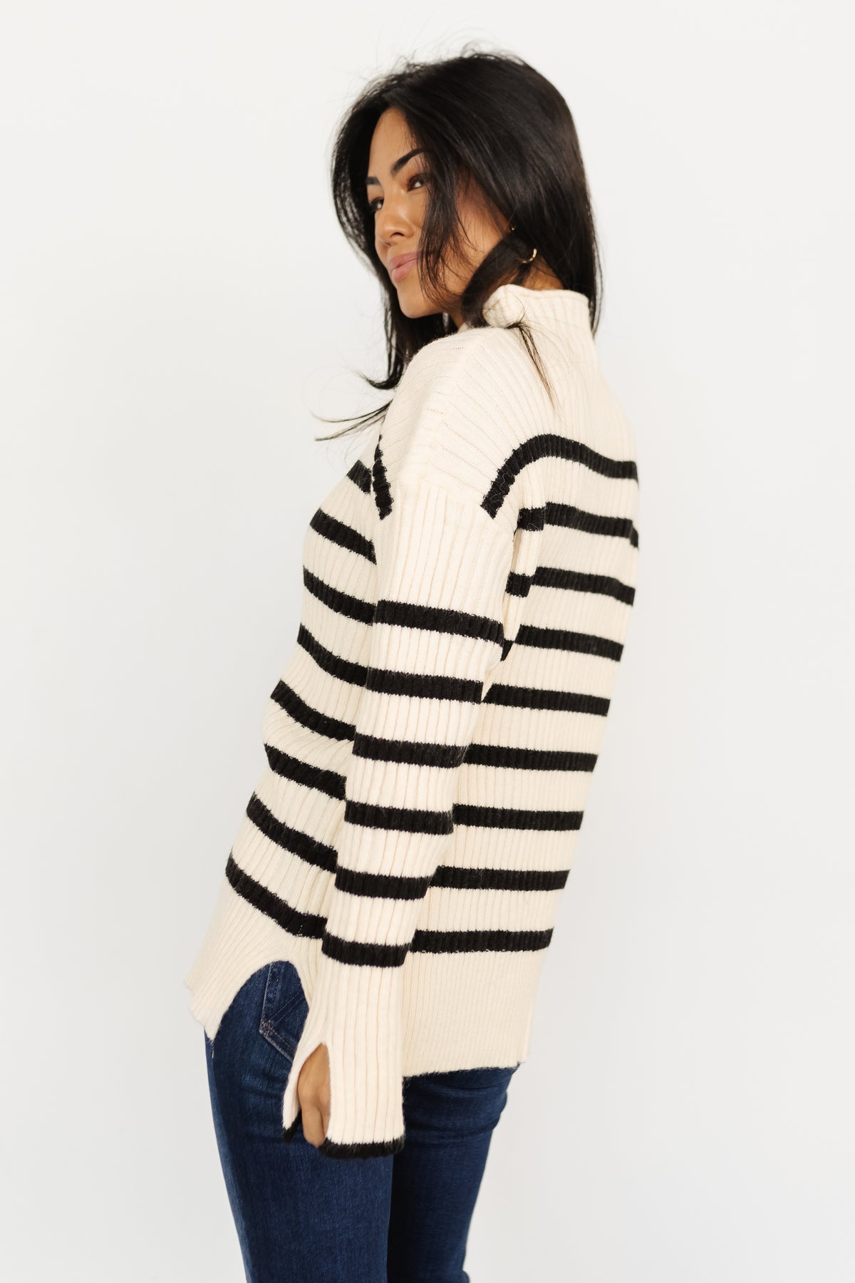 Side view of Landell striped sweater showing longline silhouette and relaxed fit, with slit detail at cuff visible.