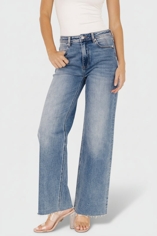 Front view of Noah high-rise straight leg jeans in medium wash on model, showing button-and-zipper fly and relaxed fit.