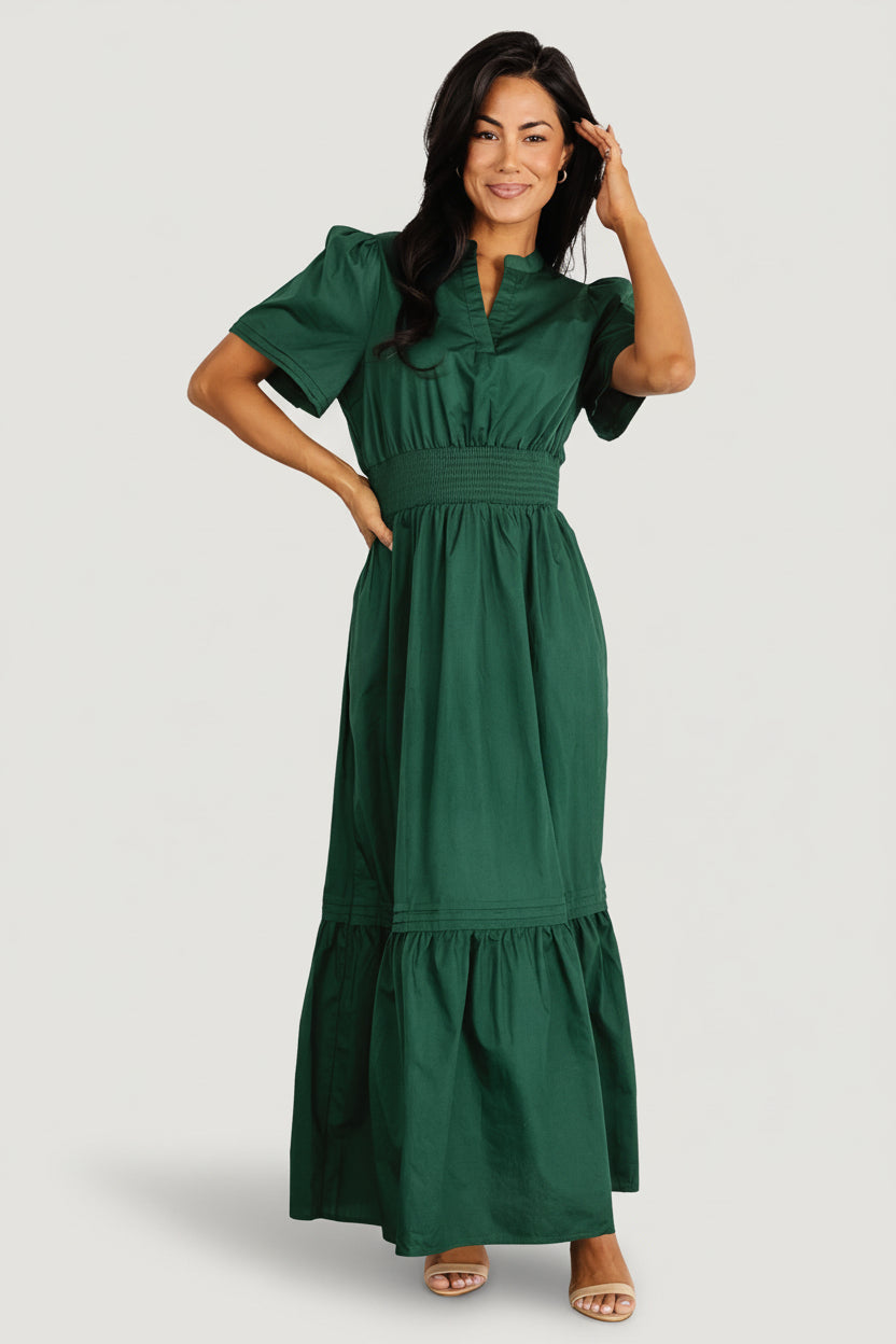 Front view of Vera Maxi Dress in emerald on a model, showing notched V-neck, smocked waistband, tiered skirt and overall silhouette, studio lighting.