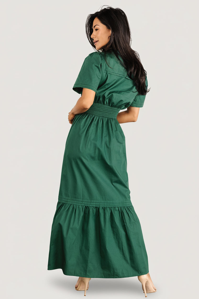 Back view of Vera Maxi Dress in emerald displaying subtle layered back detail and the tiered skirt silhouette on a model.