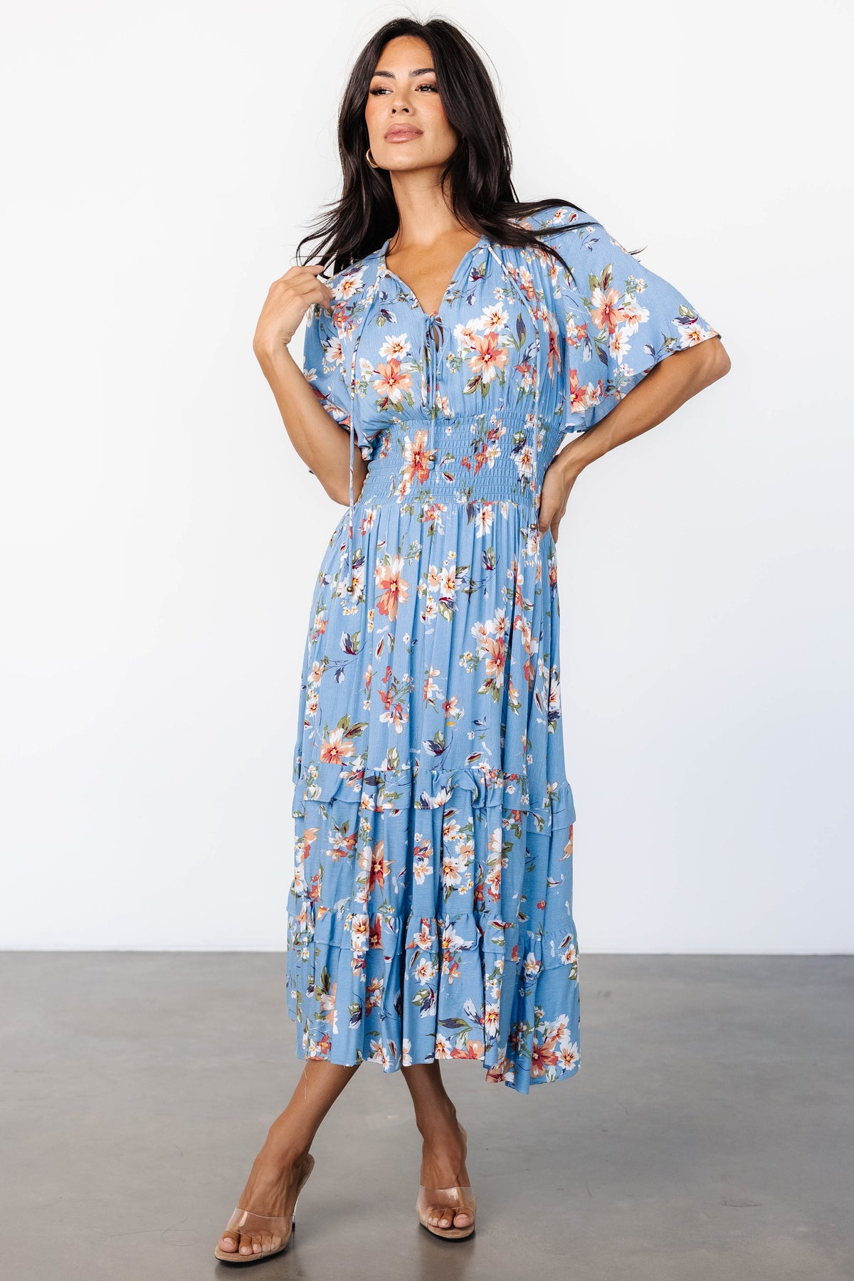 Close-up of blue and peach floral fabric and smocked waist, showing texture of the rayon shell and partial lining at mid-thigh.