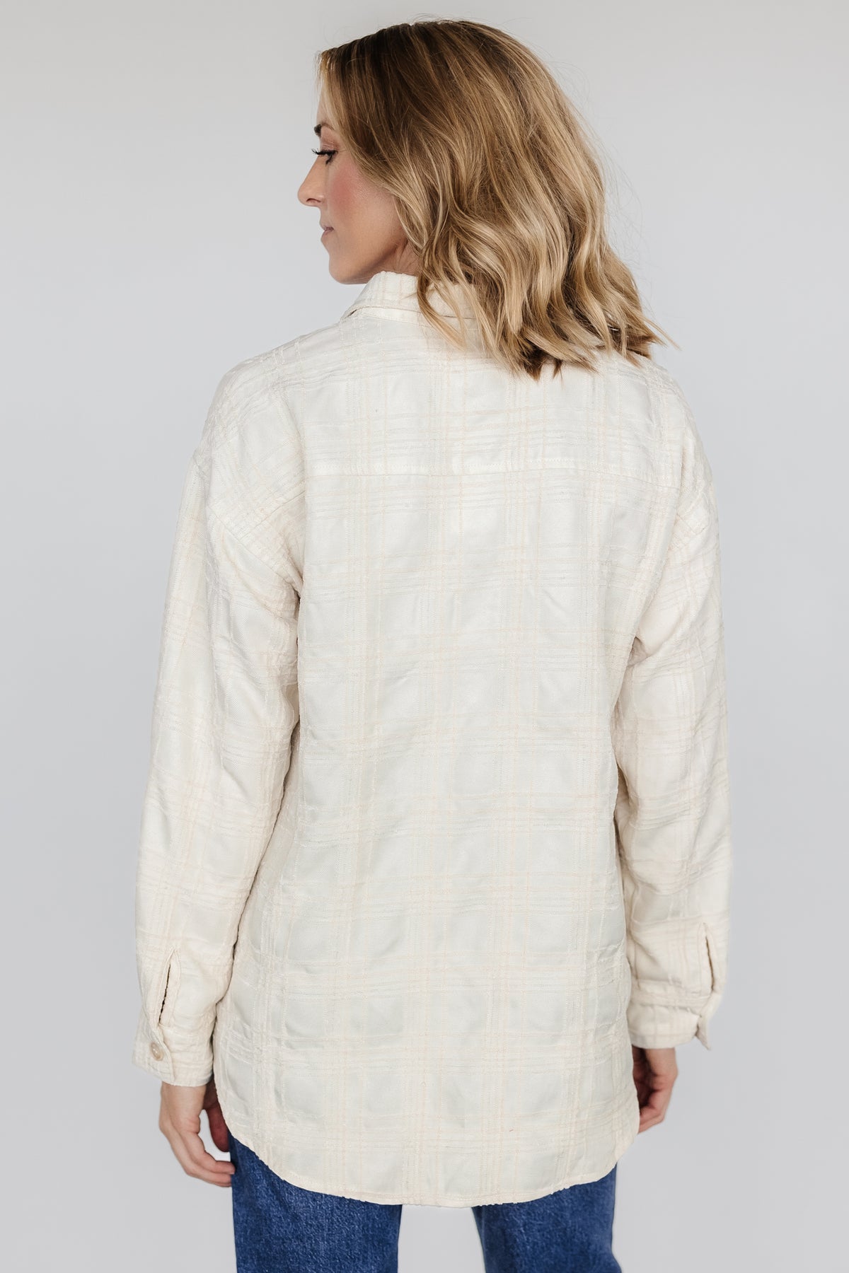 Close-up of Joanna Plaid Shacket fabric and buttons in cream and natural, showing monochromatic jacquard plaid texture and button detail.