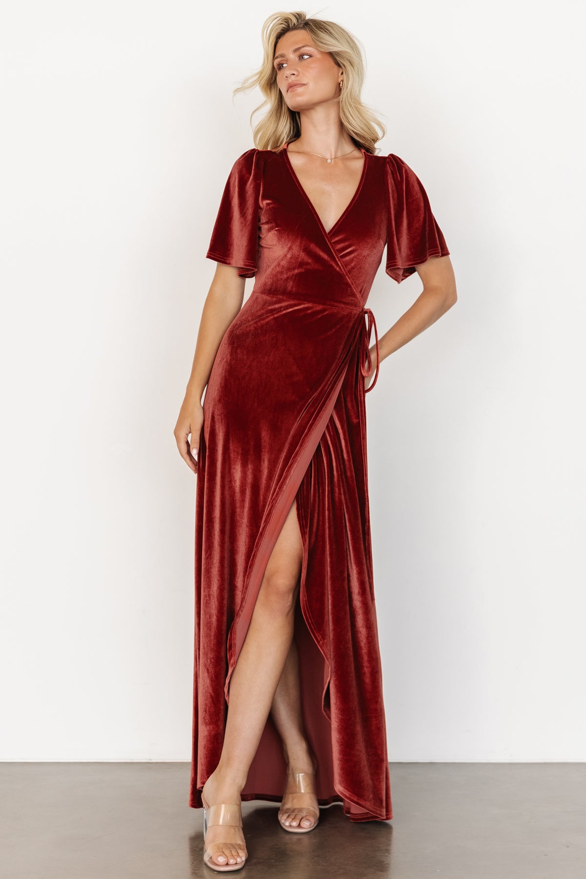 Back and side view of terracotta Katelyn velvet maxi wrap dress, showing seam lines, skirt shape, and overall maxi length on model.