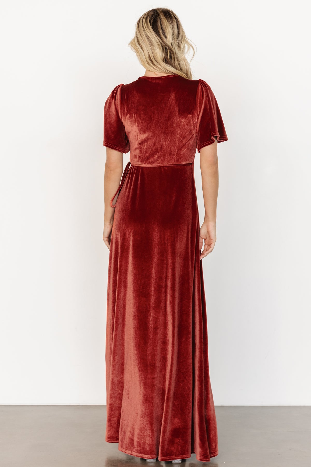 Detail shot of terracotta velvet fabric and lining, showing soft pile, rich color depth, and the fully lined interior of the dress.