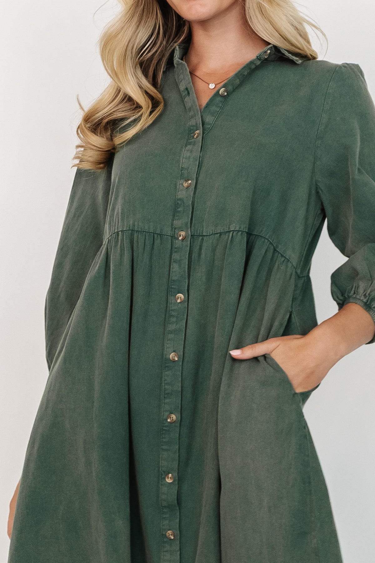 Three-quarter angle of the forest green Sari Babydoll Dress highlighting the oversized gathered sleeve, elastic cuff, and soft cotton texture.